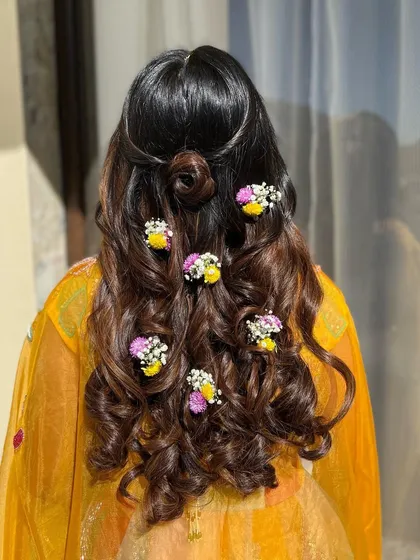 A beautiful shot of Varija's hairstyle, adorned with fresh flowers. The soft curls and floral details create a romantic and whimsical look.