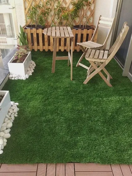Even a small balcony can become a cozy green escape. We used a combination of soft artificial turf and durable WPC deck tiles, complemented by a compact teak furniture set and planters, to create a functional and charming outdoor nook.