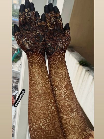 This image captures the full grandeur of an elbow-length bridal mehendi design, with intricate patterns covering every inch.