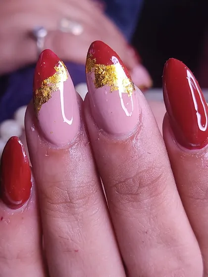 Another angle of the elegant red and gold foil almond nails.