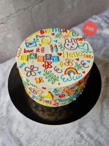 Where creativity meets cake. This playful doodle cake is covered in colorful, hand-piped drawings and messages, making it a fun and unique centerpiece for any celebration. It's a Lotus Biscoff cake inside.