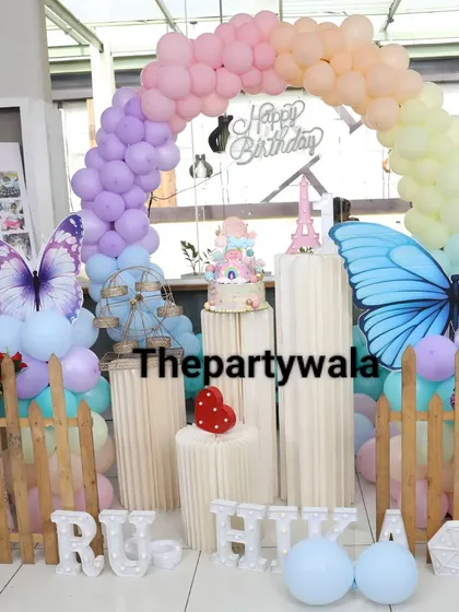 A pastel rainbow balloon arch with large butterfly cutouts makes for a very happy and colorful first birthday. I also included a milestone board to celebrate the baby's first year.
