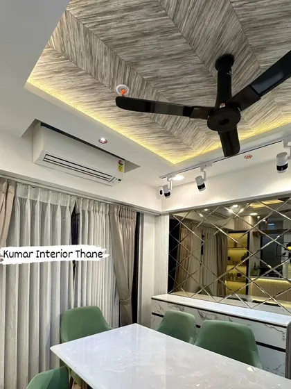 A close-up of the dining area's false ceiling with a wood-grain texture, complemented by a beveled mirror wall that adds depth and elegance.