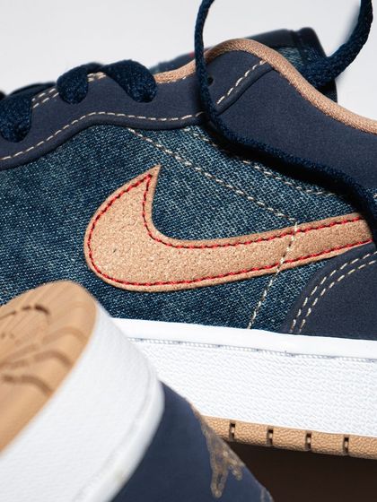 Another angle of the Jordan 1 Low 'Denim', focusing on the texture of the suede swoosh and the contrast stitching.