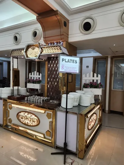 This dedicated station for plates is part of a larger, ornate buffet setup. The design ensures smooth guest flow and adds to the overall aesthetic of the event.