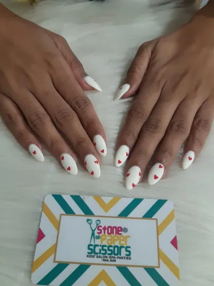 Classic and romantic, this set features crisp white stiletto nails with tiny, hand-painted red hearts. It's a simple yet impactful design that's perfect for any occasion.
