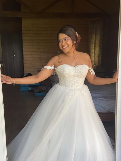 A happy bride ready for her white wedding, her hair styled in a beautiful and classic updo.