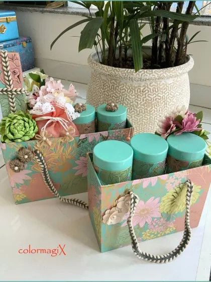 Our floral patterned gift bags filled with matching canisters. This image shows how even our simpler gift bags are designed with elegance, featuring sturdy rope handles and decorative embellishments.