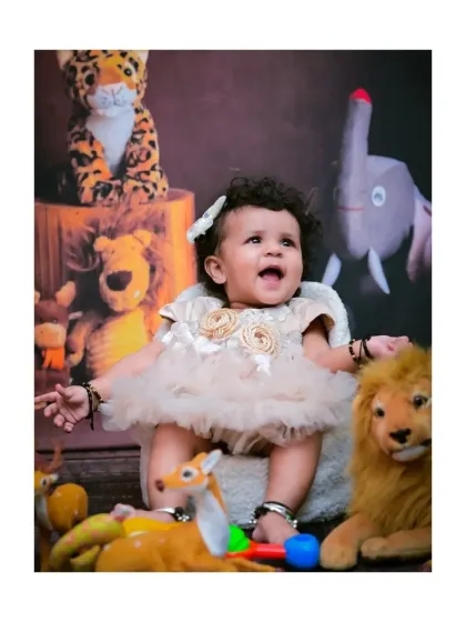 This little explorer is having a wonderful time in her jungle-themed sitter session, surrounded by friendly stuffed animals. Her joyful, open-mouthed expression is absolutely precious.