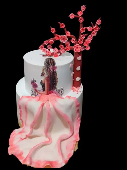 An elegant two-tiered cake with a flowing dress design. The hand-painted figure and delicate cherry blossom tree make this a work of edible art.