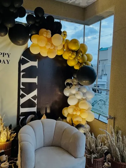 Another angle of the 60th birthday decor, showing the comfortable seating and pampas grass arrangements that add a touch of boho-chic to the modern setup.