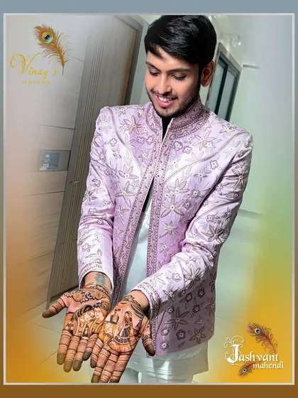 The groom's excitement is visible as he shows off his completed mehndi design.