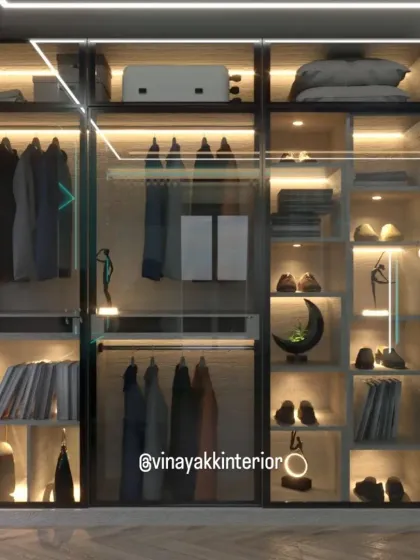 A modern wardrobe should be more than just storage; it should be a display. This walk-in closet features transparent glass shutters and integrated LED lighting, turning the daily routine of picking an outfit into a boutique experience.