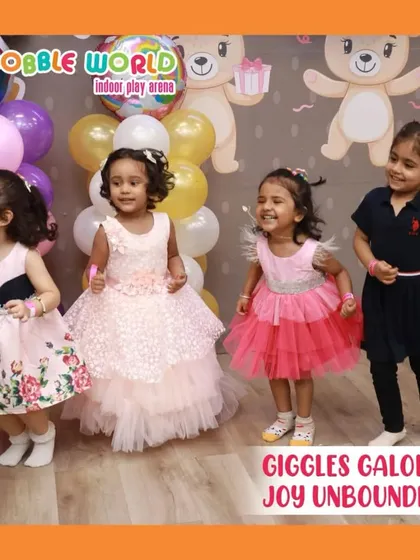Giggles and joy are guaranteed. A group of young girls in their party dresses, laughing and dancing together during a celebration.