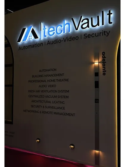 A close-up of our illuminated company logo and the list of services we offer, displayed at our exhibition booth. We provide a comprehensive range of solutions, from automation and building management to architectural lighting and security.