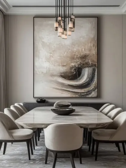 A dining room designed for memorable gatherings. The space is centered around a large marble-top table and comfortable upholstered chairs, set under a contemporary chandelier. The large abstract artwork adds a splash of color and sophistication, creating an elegant atmosphere for both family dinners and formal entertaining.