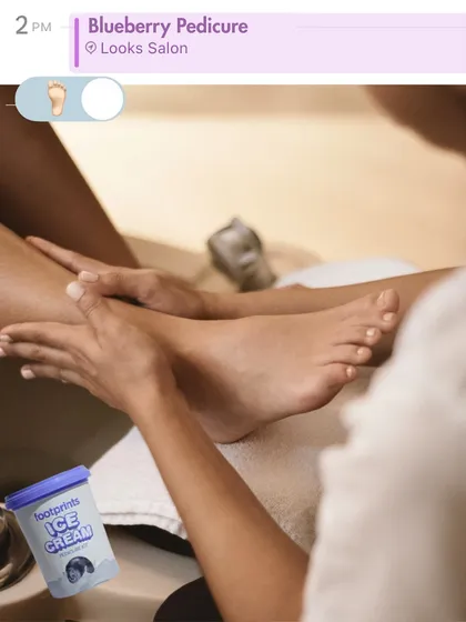 A snapshot of self-care. This image shows a client enjoying our signature Blueberry Ice Cream Pedicure, a treatment designed to soothe and refresh tired feet.