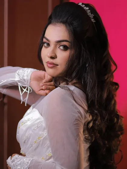 A model posing in a white gown, showing off a modern and elegant Christian wedding look.