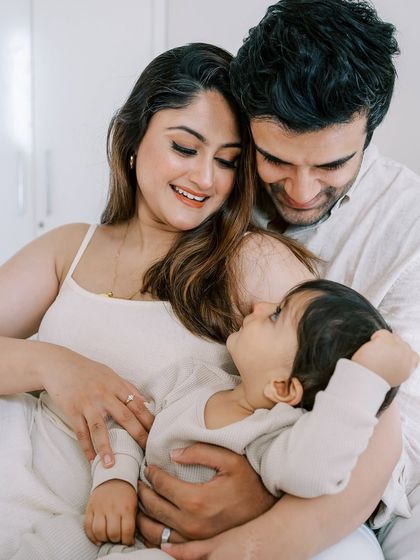The best photos often happen when they are unposed and unplanned. This intimate family cuddle on the bed is a perfect example of capturing natural love and connection.
