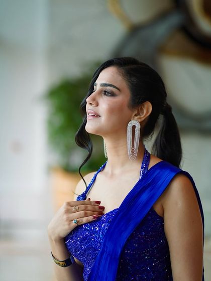 A profile shot showing off the chic ponytail and statement earrings that complete this modern ethnic look.