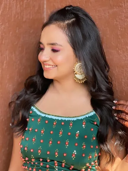 A portrait of the happy bridesmaid, her hair styled to complement her festive outfit.