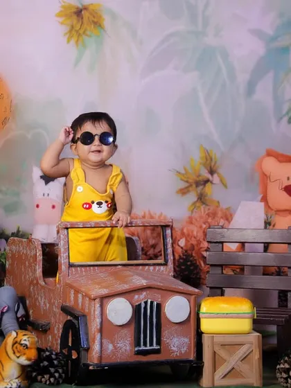 Let your toddler's personality shine in a fun themed shoot like this Jungle Explorer setup. With a cool pair of sunglasses and a mini jeep, this little adventurer is ready for anything, surrounded by friendly stuffed animals and safari-themed props.
