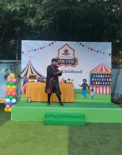 A mid-performance shot showing my stage presence and classic magician attire at the school event.