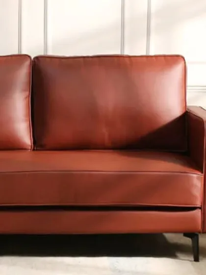 This sofa in a rich brown leatherette offers a sleek, modern look. The material is durable and easy to clean, making it a practical choice for families.