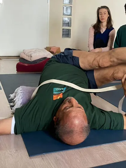 A supported bridge pose with a strap.