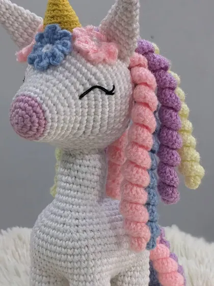 A magical unicorn with a rainbow-colored curly mane and a golden horn. This handmade amigurumi is perfect for anyone who loves a bit of fantasy and sparkle.