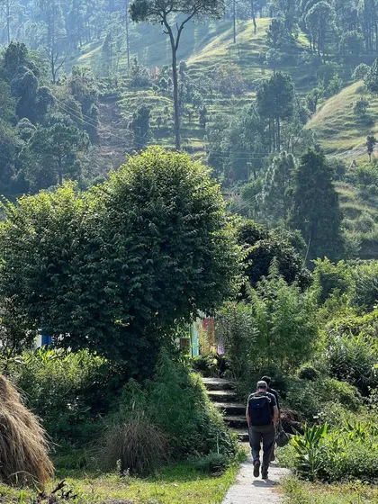 Team members walk the path towards the guesthouse site in Vasudev. The journey on foot through the agricultural terraces, or 'khets', is a constant source of inspiration for our design approach.