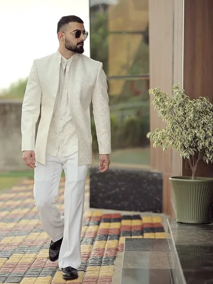 A dynamic shot of our client walking in his bespoke ivory ensemble. The outfit moves with him, demonstrating the comfort and impeccable tailoring of our formal wedding wear.