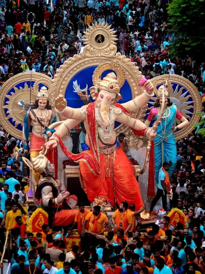 The grandeur of the procession is undeniable. This high-angle shot captures the idol surrounded by a massive, energetic crowd of worshippers.