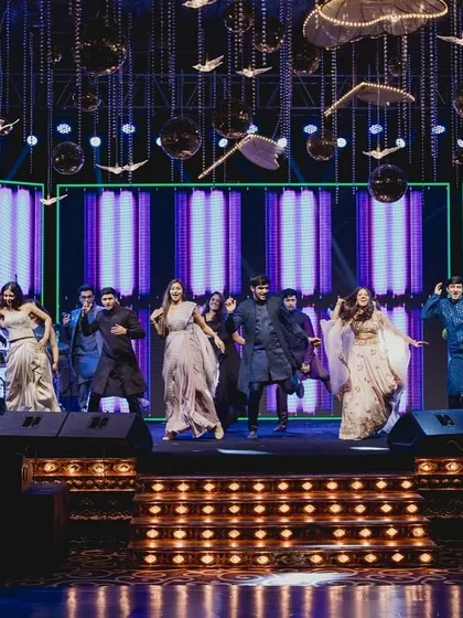 Nothing like a friends' sangeet. A wide shot of the entire group enjoying their moment on the big stage.