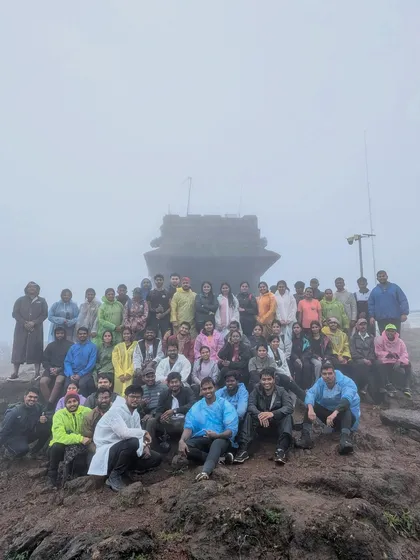 Our group posing in front of the Sarvajna Peetha at the Kodachadri summit, shrouded in mist.