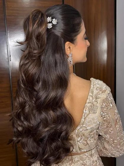Hair that makes a statement. I created this glamorous half-up ponytail with voluminous, cascading waves and delicate floral clips for a client's cocktail party. It’s chic, modern, and photographs beautifully from every angle.