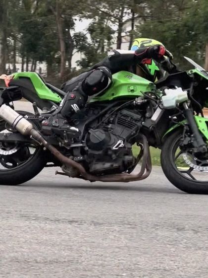 A rider on a modified Kawasaki Ninja pushes hard through a turn. Our track is a training ground where you can test your bike's performance and your own skills.