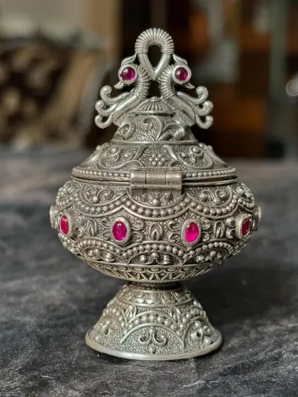 Another angle of our stunning silver kumkum box. The detailed engraving and the vibrant pink stones make it a decorative piece as well as a functional pooja item.