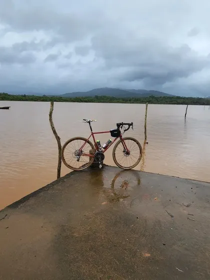 A bike stands on a jetty against the backdrop of the monsoon-swollen backwaters of Gokarna. The dramatic scenery makes for incredible cycling and photography.