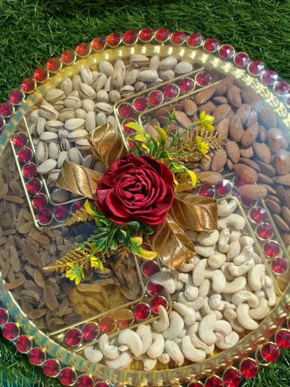 A decorative dry fruit platter with sections for cashews, almonds, pistachios, and raisins, perfect for wedding events.