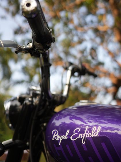 A detailed close-up of the Royal Enfield's purple fuel tank. Product detail shots like this are important for showcasing craftsmanship and brand identity within a larger lifestyle campaign.