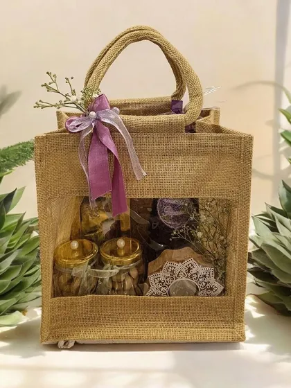 This eco-friendly jute bag with a clear window is a great way to present your Diwali gifts. Here, I've filled it with jars of dry fruits and a decorative mirror piece, creating a sustainable and charming hamper.