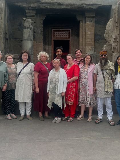 A group photo with students in front of an ancient rock-cut temple. Exploring these sacred sites together adds a deep historical and spiritual dimension to our yoga retreats.