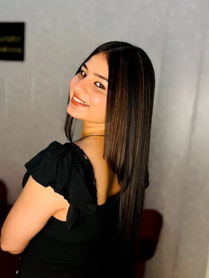 A happy client showing off her new sleek hair with subtle, face-framing highlights. This look adds brightness and dimension without being overpowering.