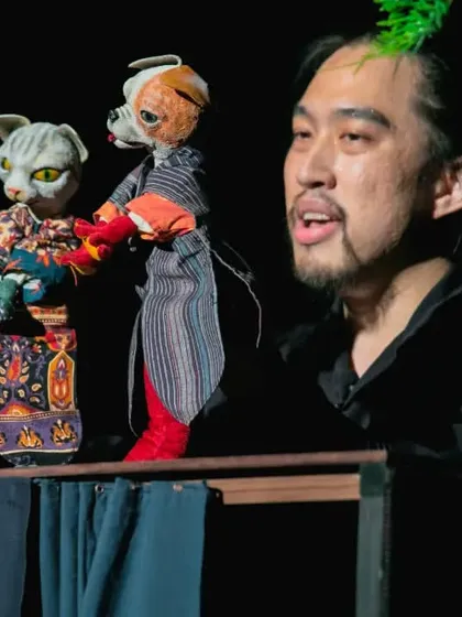 The puppeteer of 'Hiss & Arf' from Taiwan introduces his cat and dog glove puppets. The show uses traditional Taiwanese puppetry techniques in a contemporary, wordless performance.