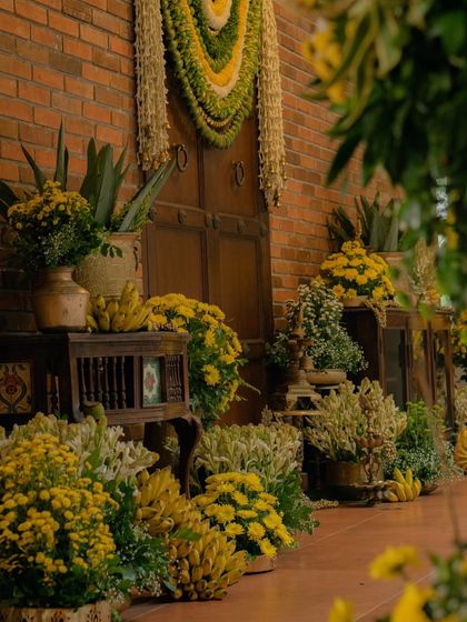We flanked the entrance with arrangements of yellow chrysanthemums, traditional brass lamps, and banana bunches. This created an inviting and auspicious entryway for a beautiful home-style wedding.