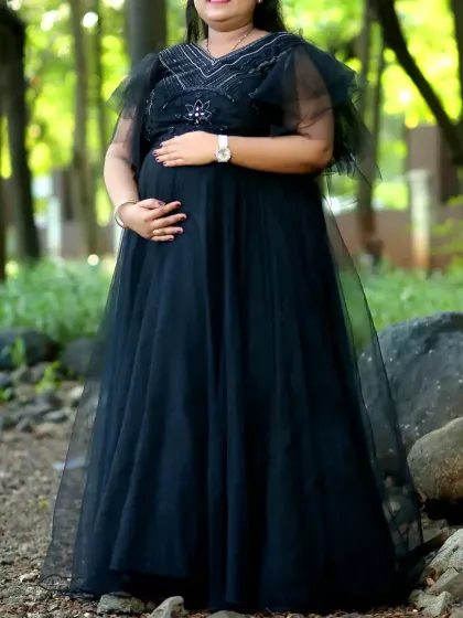 A classic black handwork gown designed for maternity shoots. The delicate details on the bodice add a touch of sparkle and elegance.