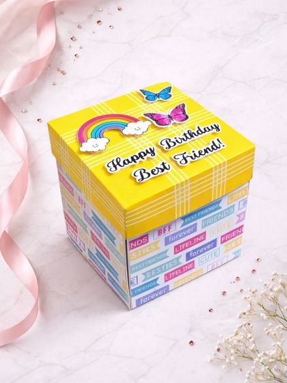A bright and cheerful birthday surprise for a best friend. This yellow explosion box is decorated with rainbows and butterflies, ready to be filled with your shared memories.