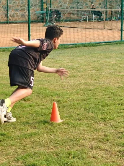 A young player at our Cambridge School, NFC centre, focuses on an agility drill, learning to change direction quickly.