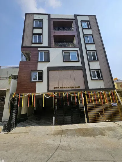 A frontal view of the completed mixed-use building, highlighting the entrance and the interplay of different textures and colors on the facade.